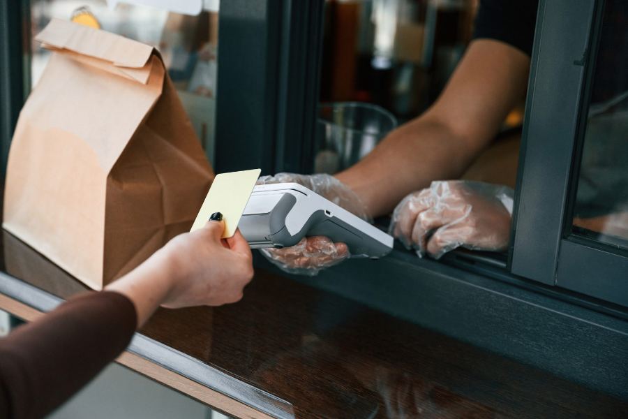 Cliente pagando com cartão na maquininha no balcão