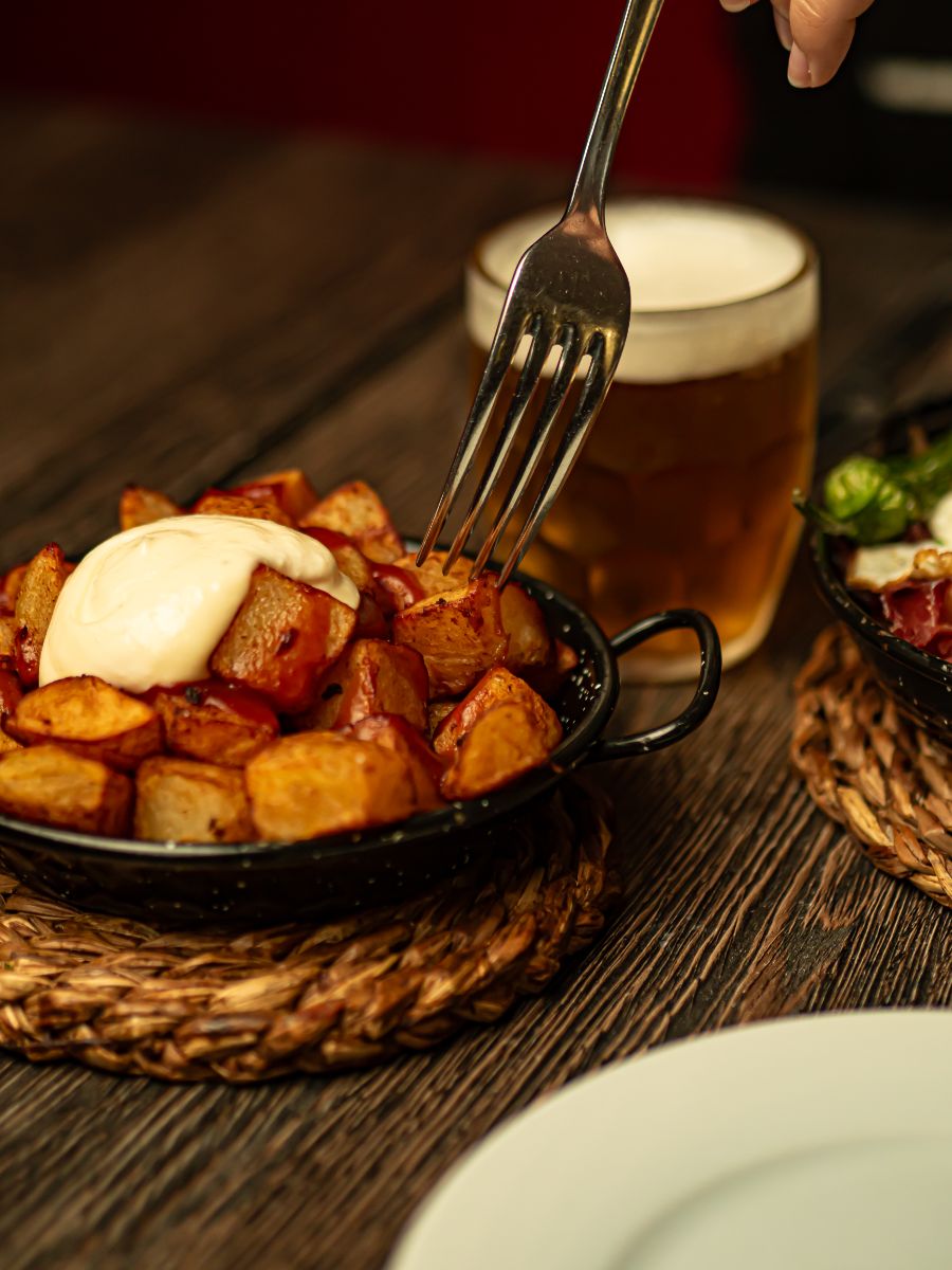 Porção de batata e chope servidos na mesa do bar