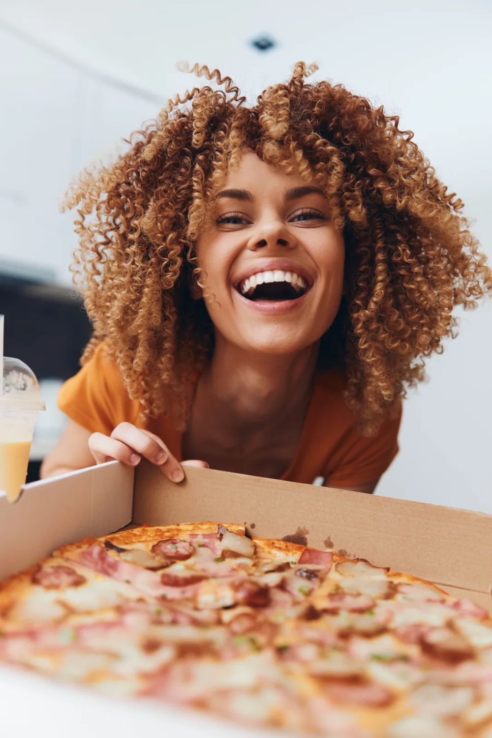 Cliente abrindo a caixa de pizza entregue em casa