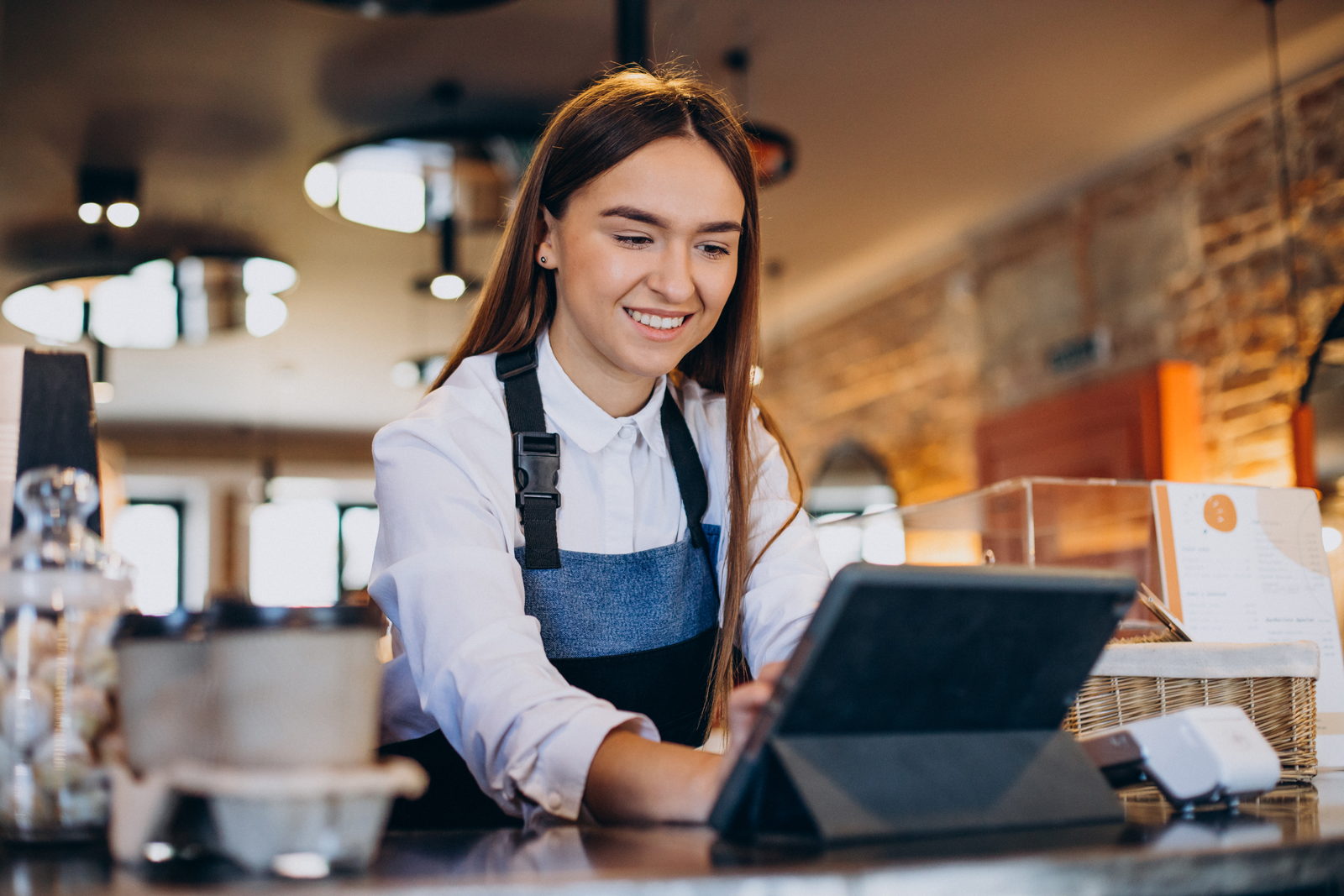 Atendente conferindo os números do restaurante no tablet