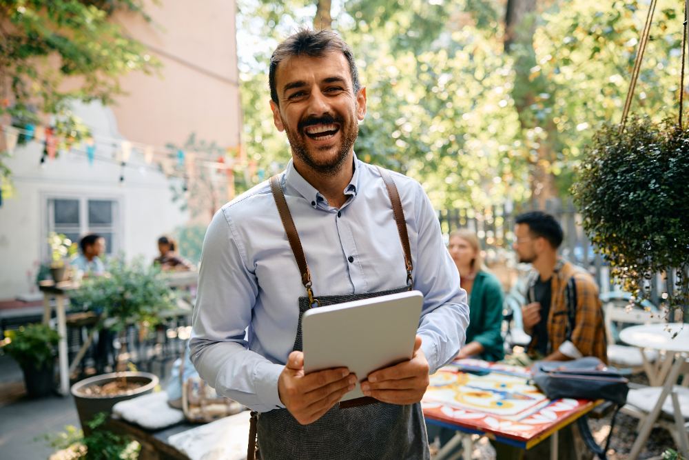 Gestor acompanhando o movimento do salão com o tablet na mão